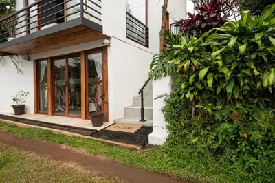 a white house with a glass door and plants at Yaloco House Monteverde in Monteverde Costa Rica