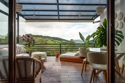 a balcony with a table and chairs and a view at Yaloco House Monteverde in Monteverde Costa Rica