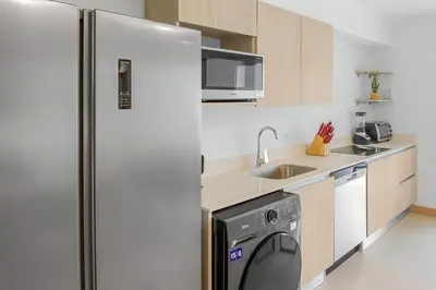 a kitchen with a refrigerator and a dishwasher at Incredible Views - Brand-New 3BR Condo in Jacó