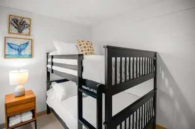 a black bunk bed in a room with a table at Incredible Views - Brand-New 3BR Condo in Jacó