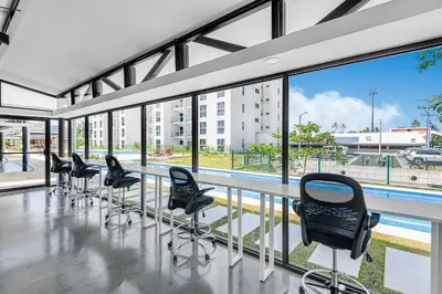 a row of chairs in a room with a pool at Incredible Views - Brand-New 3BR Condo in Jacó