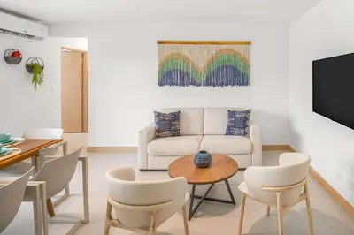 a living room with a couch and a table and chairs at Incredible Views - Brand-New 3BR Condo in Jacó
