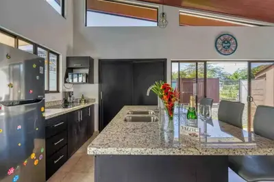 a kitchen with a counter with a sink and a refrigerator at Casa Maiki Your Private Retreat in Uvita Center in Uvita