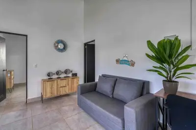 a living room with a couch and a potted plant at Casa Maiki Your Private Retreat in Uvita Center in Uvita