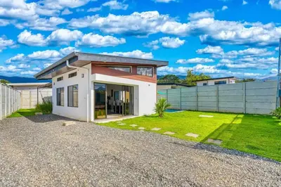a small white house with a green yard at Casa Maiki Your Private Retreat in Uvita Center in Uvita