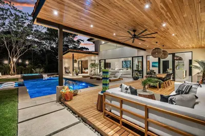 an outdoor living area with a pool and a house at Casa Ola Aloha in Playa Avellana