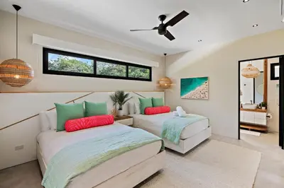 a bedroom with two beds and a ceiling fan at Casa Ola Aloha in Playa Avellana