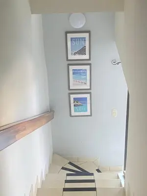 a hallway with three pictures on the wall and a staircase at Coco Maya 2b2b Villa in Coco