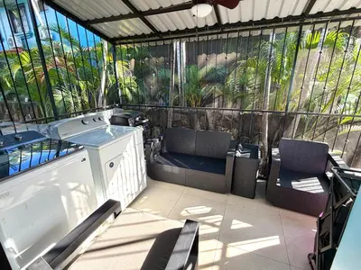 a screened in porch with chairs and a tub at Coco Maya 2b2b Villa in Coco