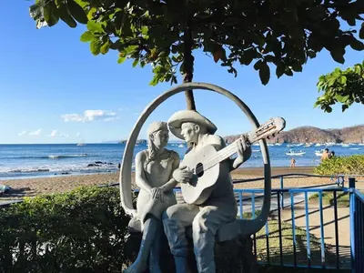 a statue of two people sitting on a bench with a guitar at Coco Maya 2b2b Villa in Coco