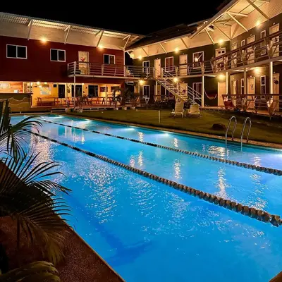 a large swimming pool at night with blue illumination at Hotel Tama Lodge in Tamarindo