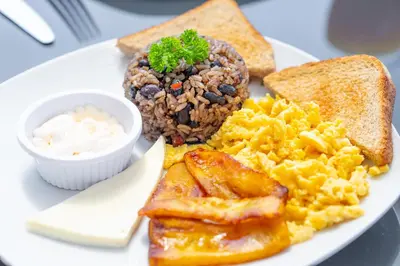 a plate of breakfast food with eggs bread and toast at Tocuma Glamping in Cartago