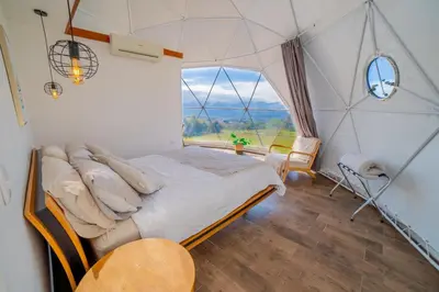 a bedroom with a large window in a dome tent at Tocuma Glamping in Cartago