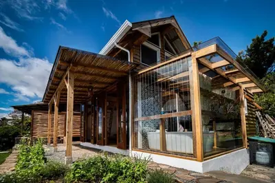 a wooden house with a glass facade at Casita Acantilado - Timber Frame Tiny House in Monteverde Costa Rica
