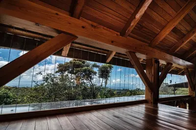 an empty room with large windows and a wooden ceiling at Casita Acantilado - Timber Frame Tiny House in Monteverde Costa Rica