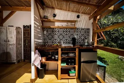 a kitchen with a stove and a refrigerator at Casita Acantilado - Timber Frame Tiny House in Monteverde Costa Rica