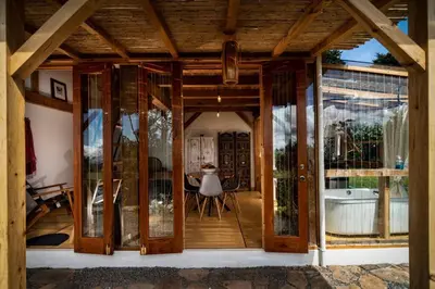 a room with glass doors and a dining room at Casita Acantilado - Timber Frame Tiny House in Monteverde Costa Rica