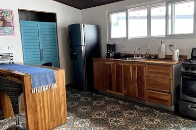 a kitchen with a refrigerator and a sink at Casa Kiv Turrialba Centro in Turrialba