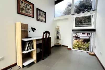 a home office with a desk and windows at Casa Kiv Turrialba Centro in Turrialba