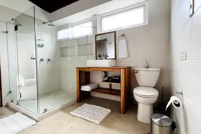 a bathroom with a shower and a toilet and a sink at Casa Kiv Turrialba Centro in Turrialba