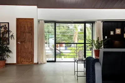 a living room with a door and a couch and a table at Casa Kiv Turrialba Centro in Turrialba