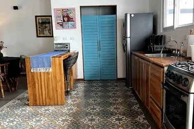 a kitchen with a refrigerator and a counter with a sink at Casa Kiv Turrialba Centro in Turrialba