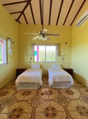 two beds in a room with a ceiling fan at Guayabo Animal Rescue & Sanctuary in Hacienda Miravalles