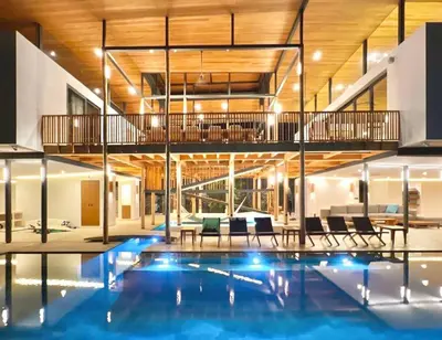 a house with a swimming pool with chairs and a balcony at Nimbu West in Tamarindo