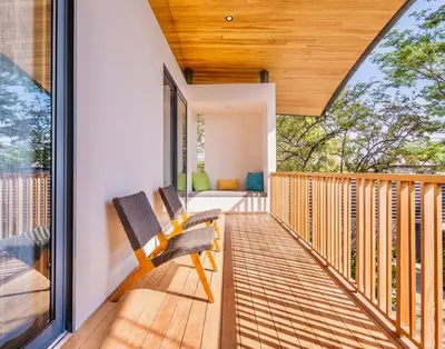 a wooden porch with a bench on a deck at Nimbu West in Tamarindo