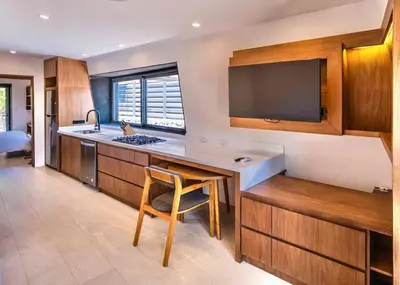 a kitchen with a sink and a counter with a chair at Nimbu West in Tamarindo