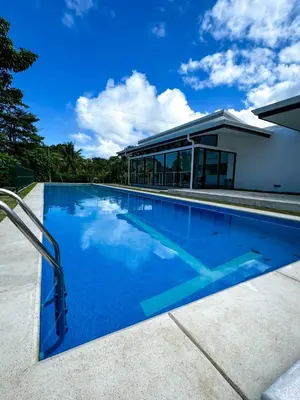 a swimming pool in front of a house at Luxury Condo at Viva Jaco Residence in Jacó