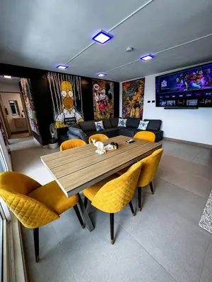 a dining room with a wooden table and yellow chairs at Luxury Condo at Viva Jaco Residence in Jacó