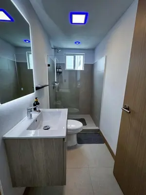 a bathroom with a sink and a toilet and a mirror at Luxury Condo at Viva Jaco Residence in Jacó