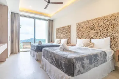 two beds in a room with a large window at Casa Frenchie & Villas Vista del Mar - by Pura Villas in Dominicalito