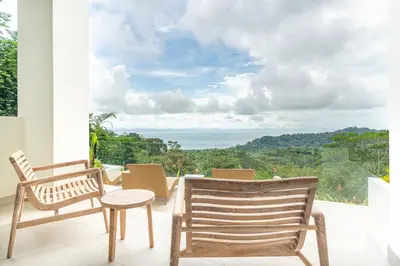 two chairs and a table on a balcony with a view at Casa Frenchie & Villas Vista del Mar - by Pura Villas in Dominicalito