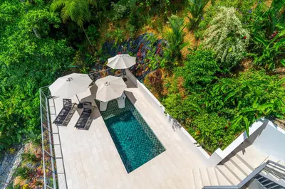 an overhead view of a swimming pool with umbrellas at Casa Frenchie & Villas Vista del Mar - by Pura Villas in Dominicalito