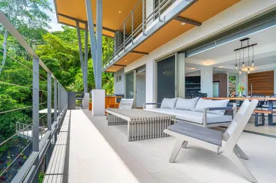 an outdoor patio with a couch and a table at Casa Frenchie & Villas Vista del Mar - by Pura Villas in Dominicalito