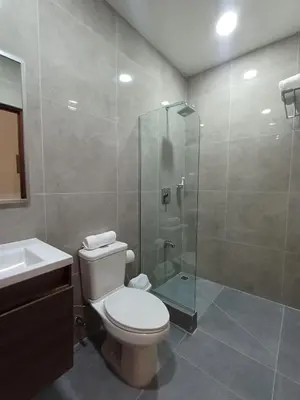 a bathroom with a toilet and a glass shower at Hotel Puerto Limón CR in Puerto Limón
