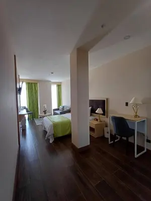 a hotel room with a bed and a desk and a bedroom at Hotel Puerto Limón CR in Puerto Limón