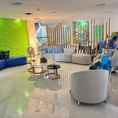 a lobby with couches and tables in a building at Hotel Puerto Limón CR in Puerto Limón