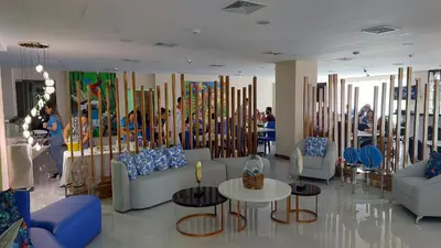 a lobby with couches and tables and people in a room at Hotel Puerto Limón CR in Puerto Limón
