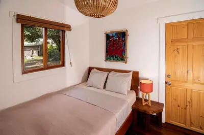 a small bedroom with a bed and a window at Casa Cabuya - Retro Style with Gulf View in Monteverde in Monteverde Costa Rica