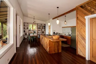 a kitchen with wooden flooring and a large island in the middle at Casa Cabuya - Retro Style with Gulf View in Monteverde in Monteverde Costa Rica