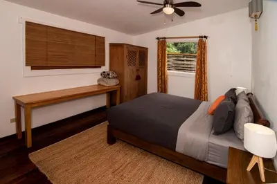 a bedroom with a bed and a desk and a window at Casa Cabuya - Retro Style with Gulf View in Monteverde in Monteverde Costa Rica