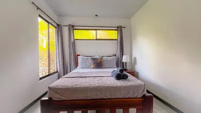 a bedroom with a bed and two windows at 3bdr House in Uvita LAPA Ocean View in Uvita