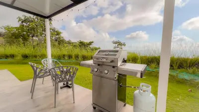 a grill on a patio with a table and chairs at 3bdr House in Uvita LAPA Ocean View in Uvita