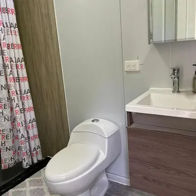 a bathroom with a white toilet and a sink at Apartamento Estilo Container in Guápiles