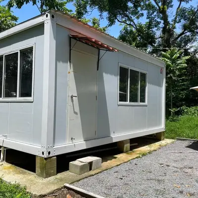 a small white trailer with the door open at Apartamento Estilo Container in Guápiles