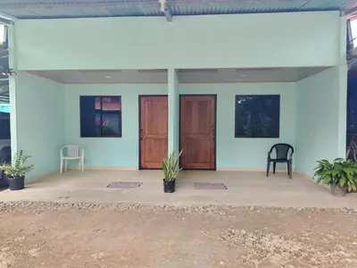 a house with blue walls and wooden doors at Cabinas El Jardin in Paquera