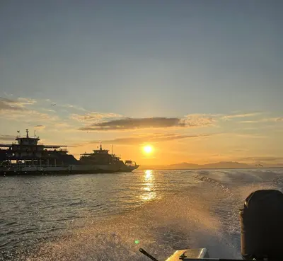 a boat in the water as the sun is setting at Cabinas El Jardin in Paquera